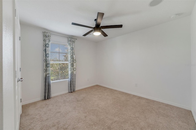 carpeted spare room featuring ceiling fan