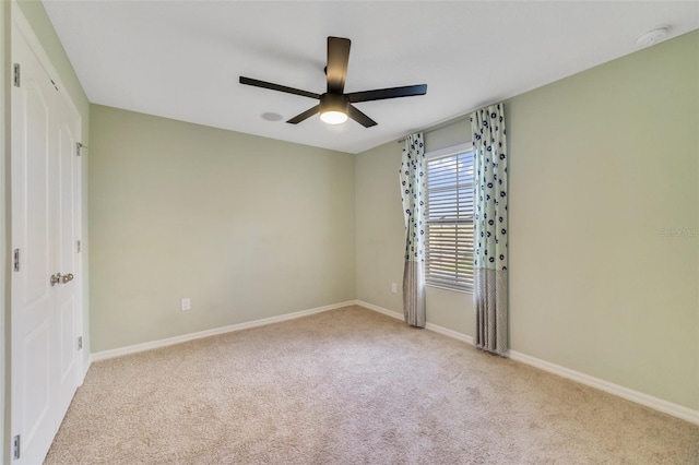 carpeted spare room featuring ceiling fan