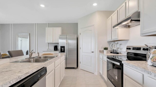 kitchen with white cabinets, light tile patterned floors, sink, and appliances with stainless steel finishes