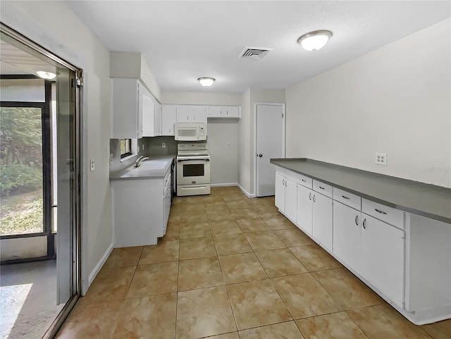 kitchen with white cabinets, white appliances, light tile patterned floors, and sink