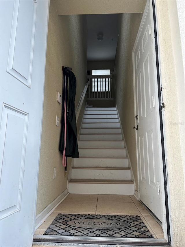 stairway featuring tile patterned flooring