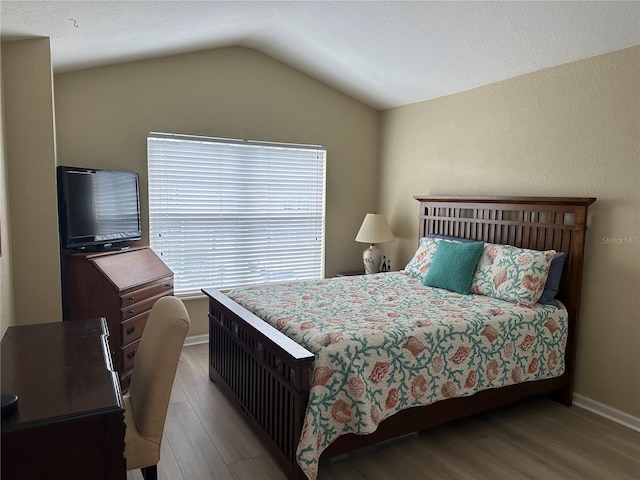 bedroom featuring light hardwood / wood-style floors and lofted ceiling