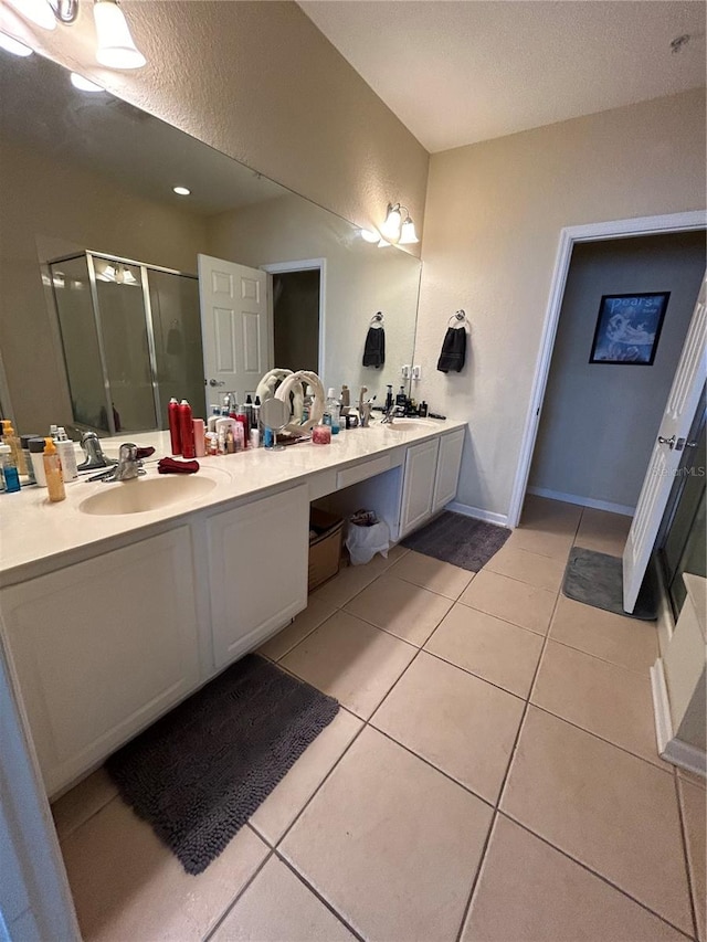 bathroom with vanity, a textured ceiling, tile patterned flooring, and a shower with shower door