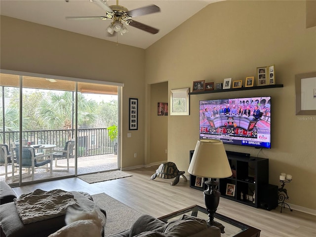 living room with ceiling fan, light hardwood / wood-style flooring, and high vaulted ceiling