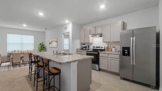 kitchen with gray cabinetry, a center island with sink, sink, and appliances with stainless steel finishes