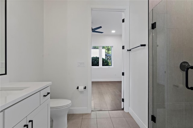 bathroom featuring toilet, vanity, hardwood / wood-style floors, and a shower with shower door