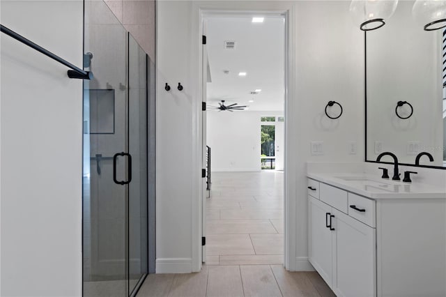 bathroom featuring walk in shower, vanity, and ceiling fan