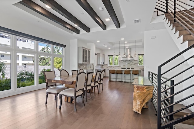 dining space with beamed ceiling and dark hardwood / wood-style floors