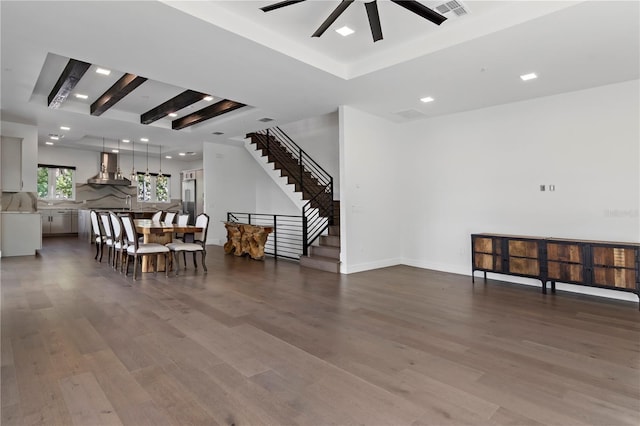 interior space with wood-type flooring, ceiling fan, and beam ceiling