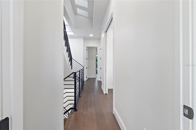 corridor with a skylight and dark hardwood / wood-style floors