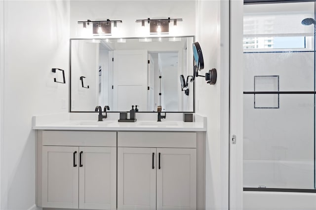 bathroom featuring a shower with door and vanity