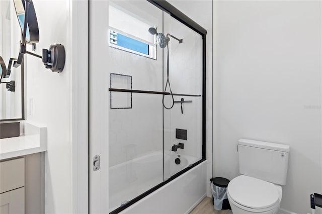 full bathroom featuring toilet, vanity, and shower / bath combination with glass door