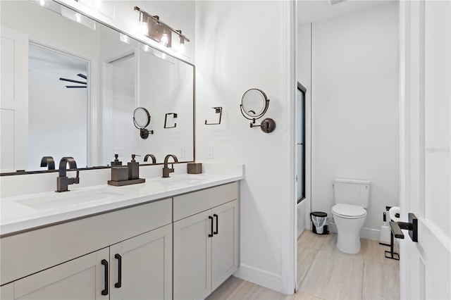 full bathroom with bath / shower combo with glass door, vanity, and toilet