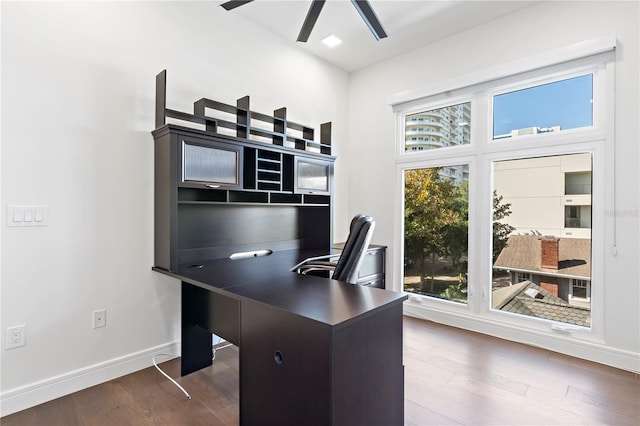 home office with dark wood-type flooring and ceiling fan