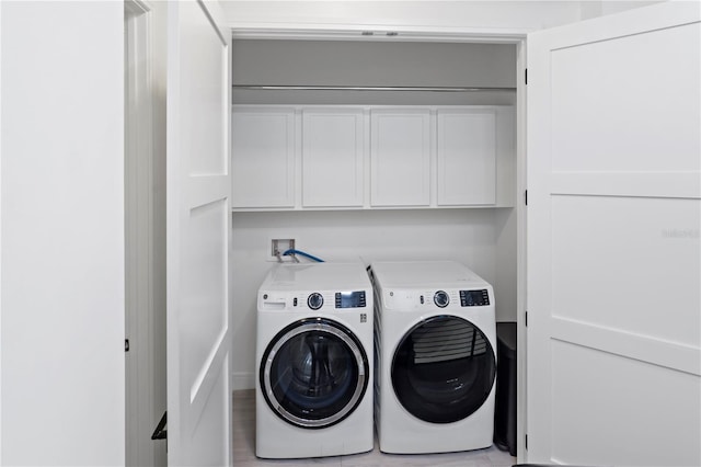 washroom with cabinets and washer and clothes dryer