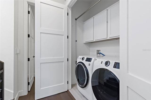 laundry room featuring dark wood-type flooring, cabinets, and separate washer and dryer