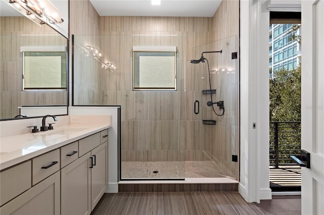 bathroom featuring hardwood / wood-style flooring, a shower with door, and vanity