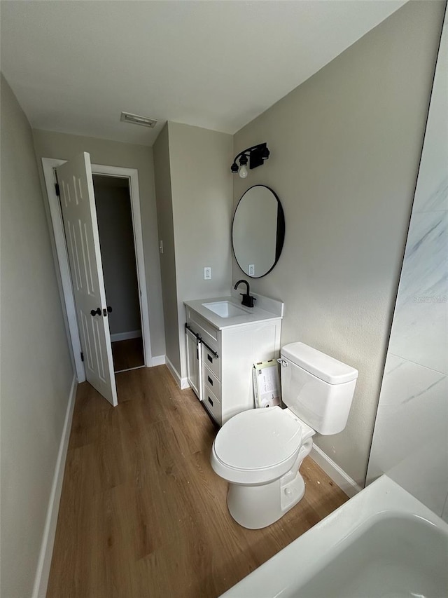 bathroom featuring vanity, hardwood / wood-style flooring, and toilet