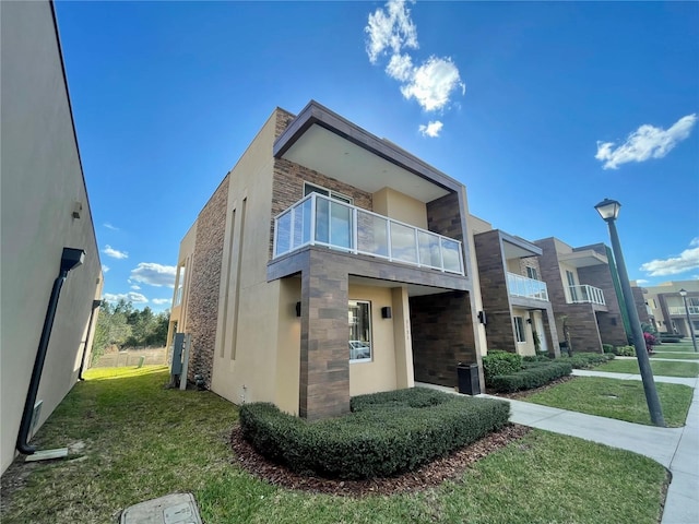 exterior space with a front lawn and a balcony