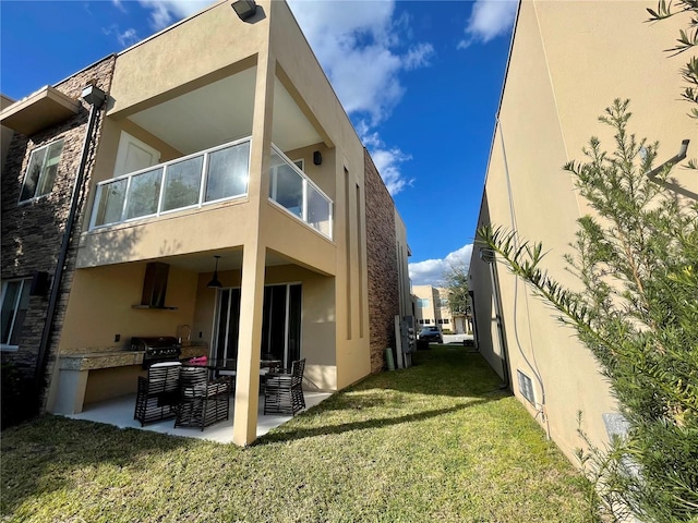 rear view of property with a lawn and a patio