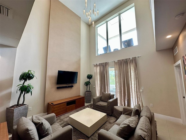 tiled living room with a high ceiling and an inviting chandelier