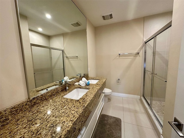 bathroom featuring toilet, vanity, tile patterned flooring, and walk in shower