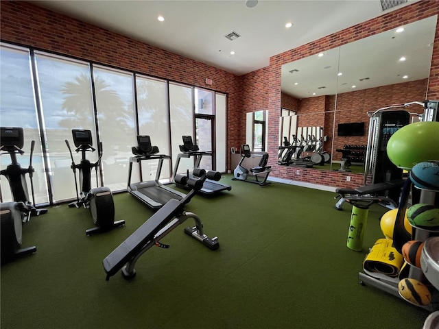 workout area featuring brick wall