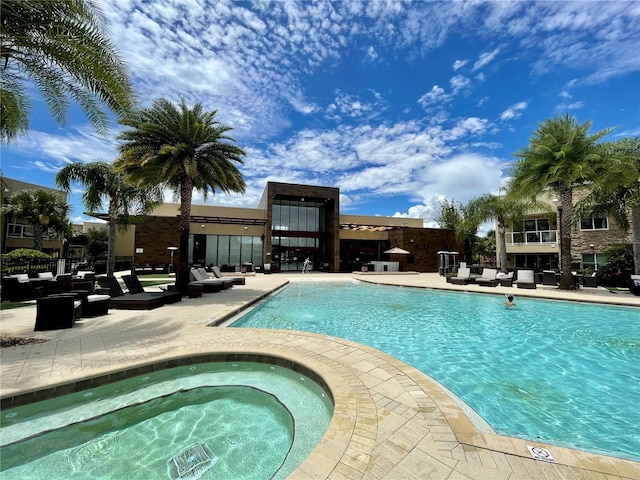 view of pool with a patio and a hot tub