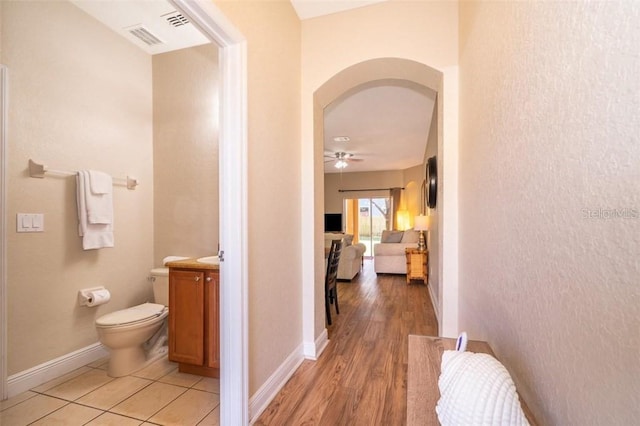 3520 Calabria Ave Unit 3520, Davenport, FL 33897 - hallway with arched walkways, baseboards, and light wood-type flooring