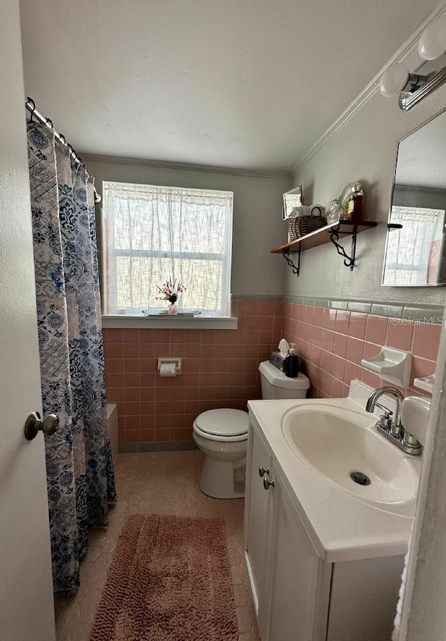 full bathroom with tile patterned flooring, vanity, crown molding, toilet, and tile walls