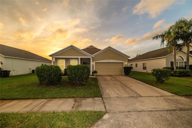 ranch-style home with a yard and a garage