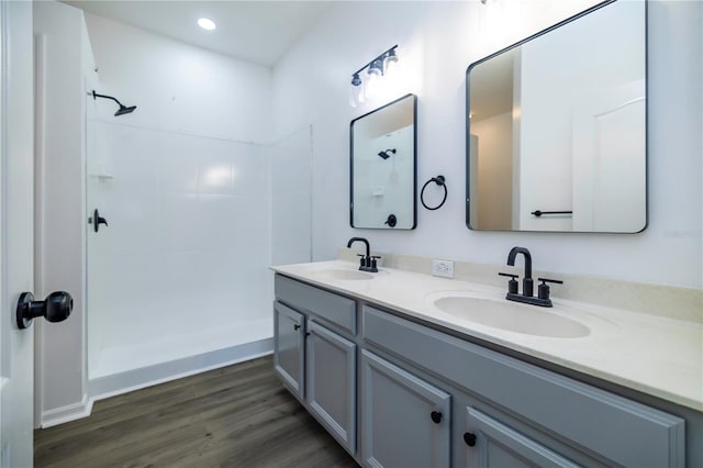 bathroom with hardwood / wood-style floors, vanity, and walk in shower