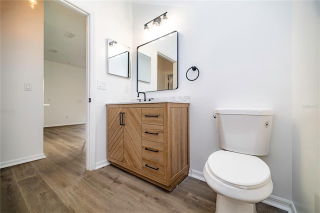 bathroom with vanity, wood-type flooring, and toilet