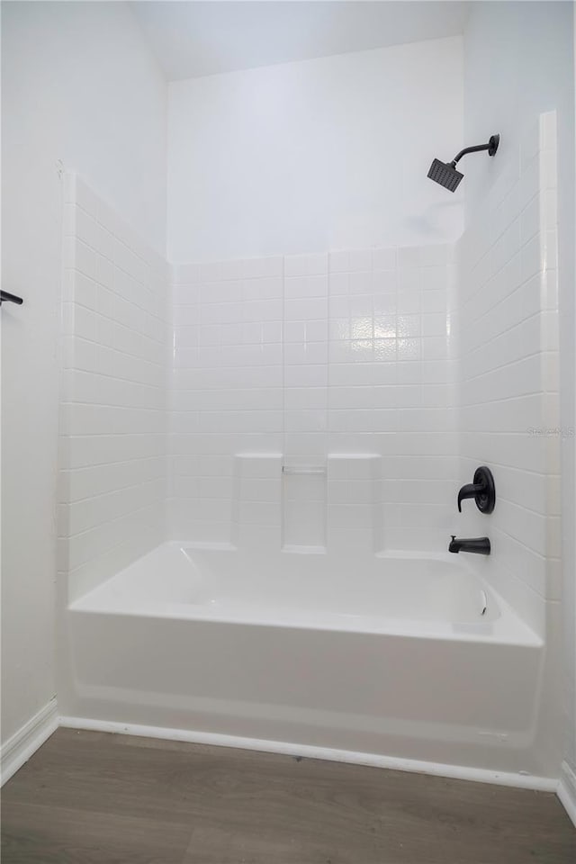 bathroom with hardwood / wood-style flooring and shower / bath combination