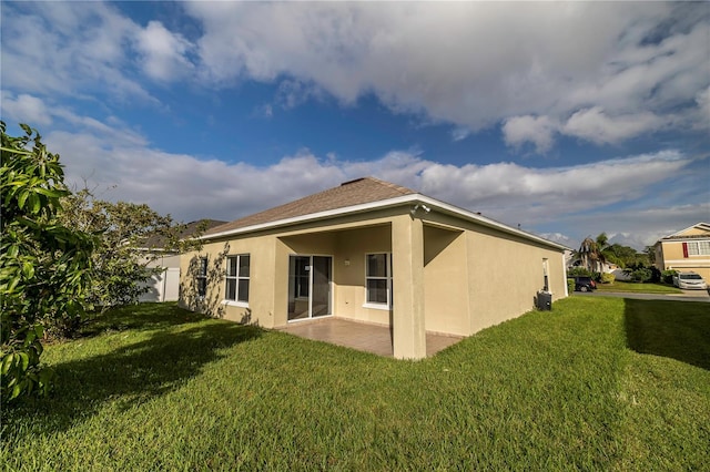 back of house with a patio area and a lawn