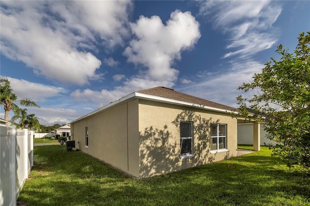 view of side of home featuring central air condition unit and a lawn