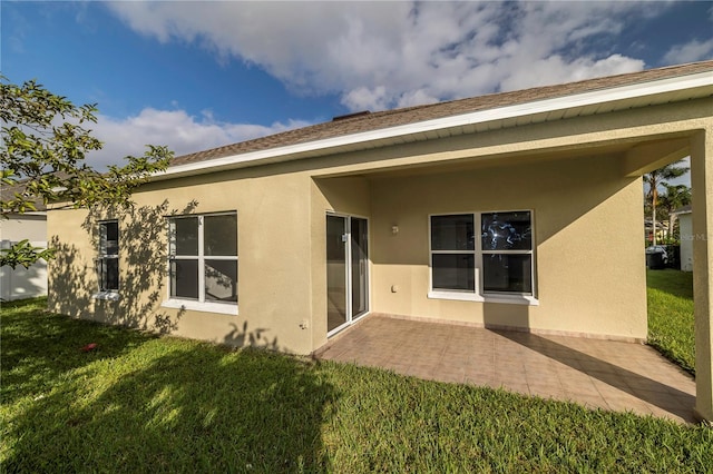 rear view of property featuring a lawn and a patio area