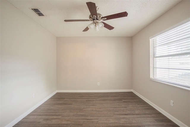 spare room with dark hardwood / wood-style floors, ceiling fan, plenty of natural light, and a textured ceiling