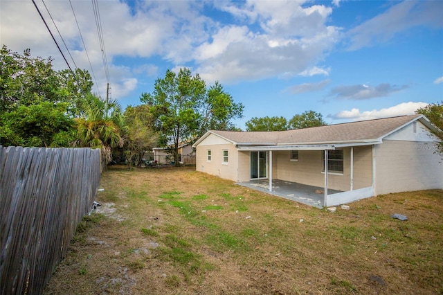 rear view of house with a patio and a lawn