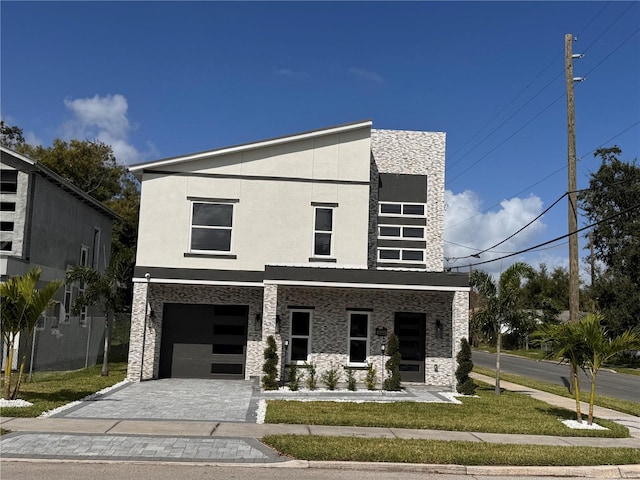 contemporary home with a garage and a front lawn