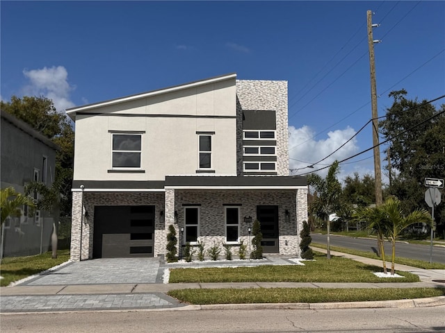 contemporary home featuring a garage and a front lawn