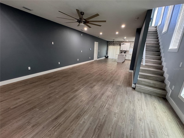 unfurnished living room featuring hardwood / wood-style flooring and ceiling fan