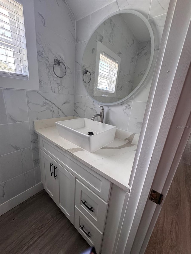 bathroom featuring hardwood / wood-style floors, vanity, and tile walls