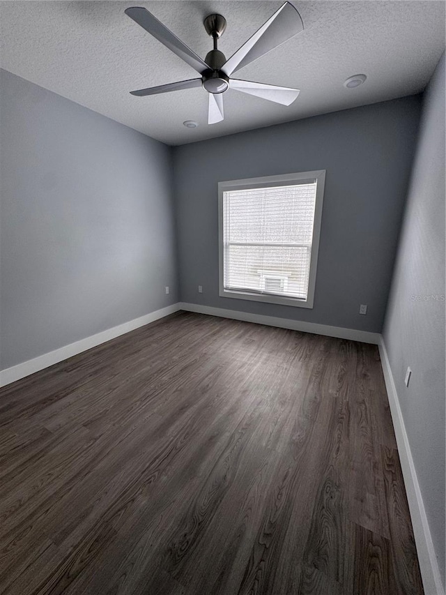 spare room featuring ceiling fan, dark hardwood / wood-style floors, and a textured ceiling