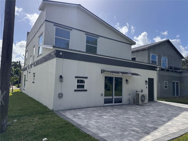 rear view of property featuring ac unit, a patio, and a yard