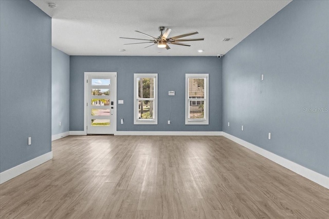 unfurnished room featuring a ceiling fan, visible vents, baseboards, and wood finished floors