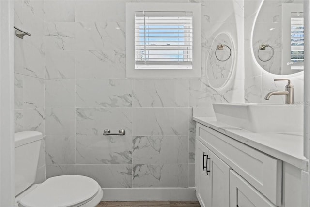 bathroom featuring toilet, tile walls, and vanity