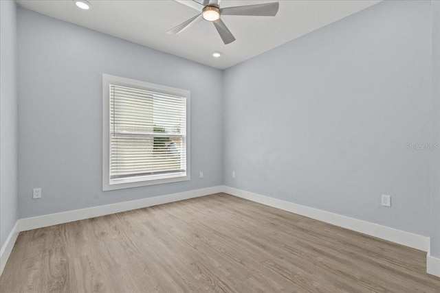 spare room with a ceiling fan, baseboards, and wood finished floors