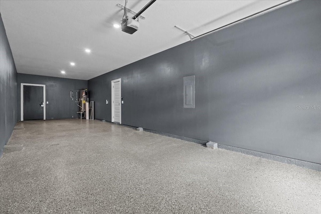 garage with recessed lighting, electric panel, and a garage door opener