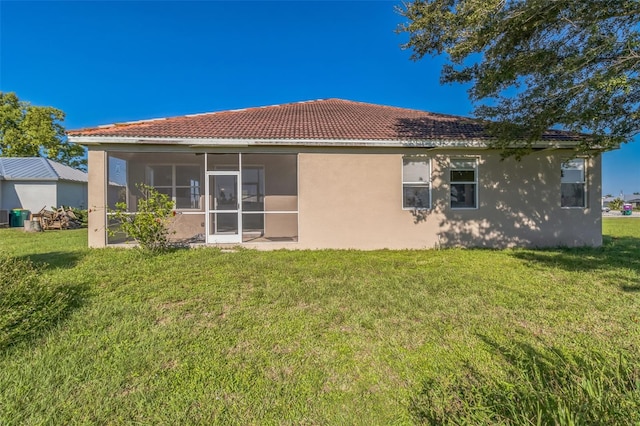 rear view of house with a sunroom and a yard